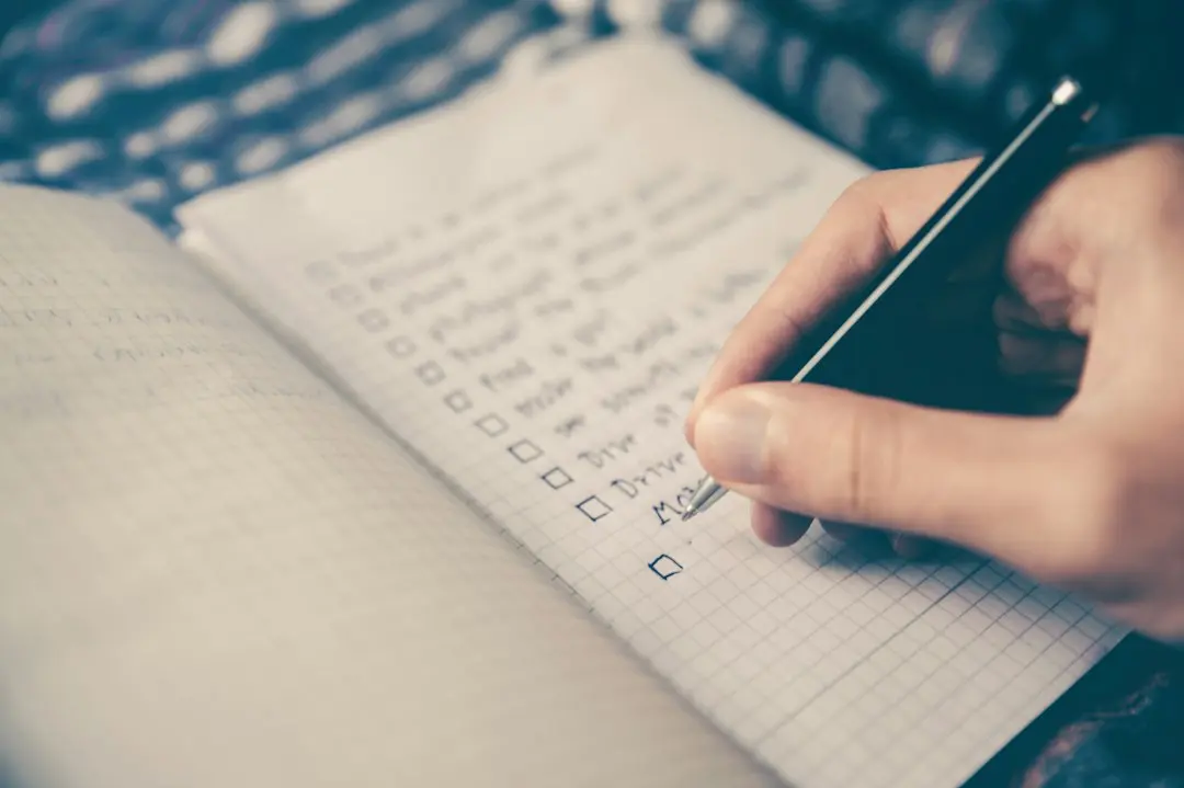 Iemand vult een checklist in een notitieboek in, om een IPTV-aanbieder zoals Swivtv te kiezen